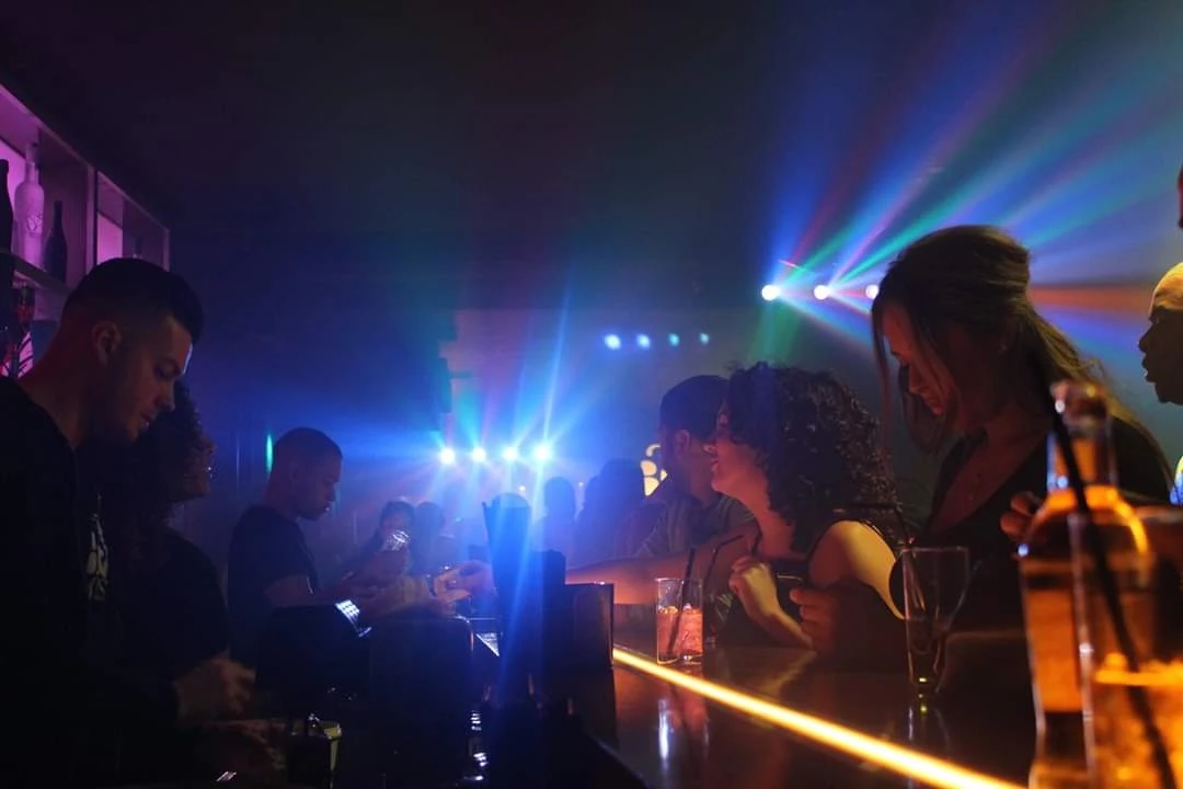 Binnen in BrasilBar: bar en dansvloer met gekleurde lichten